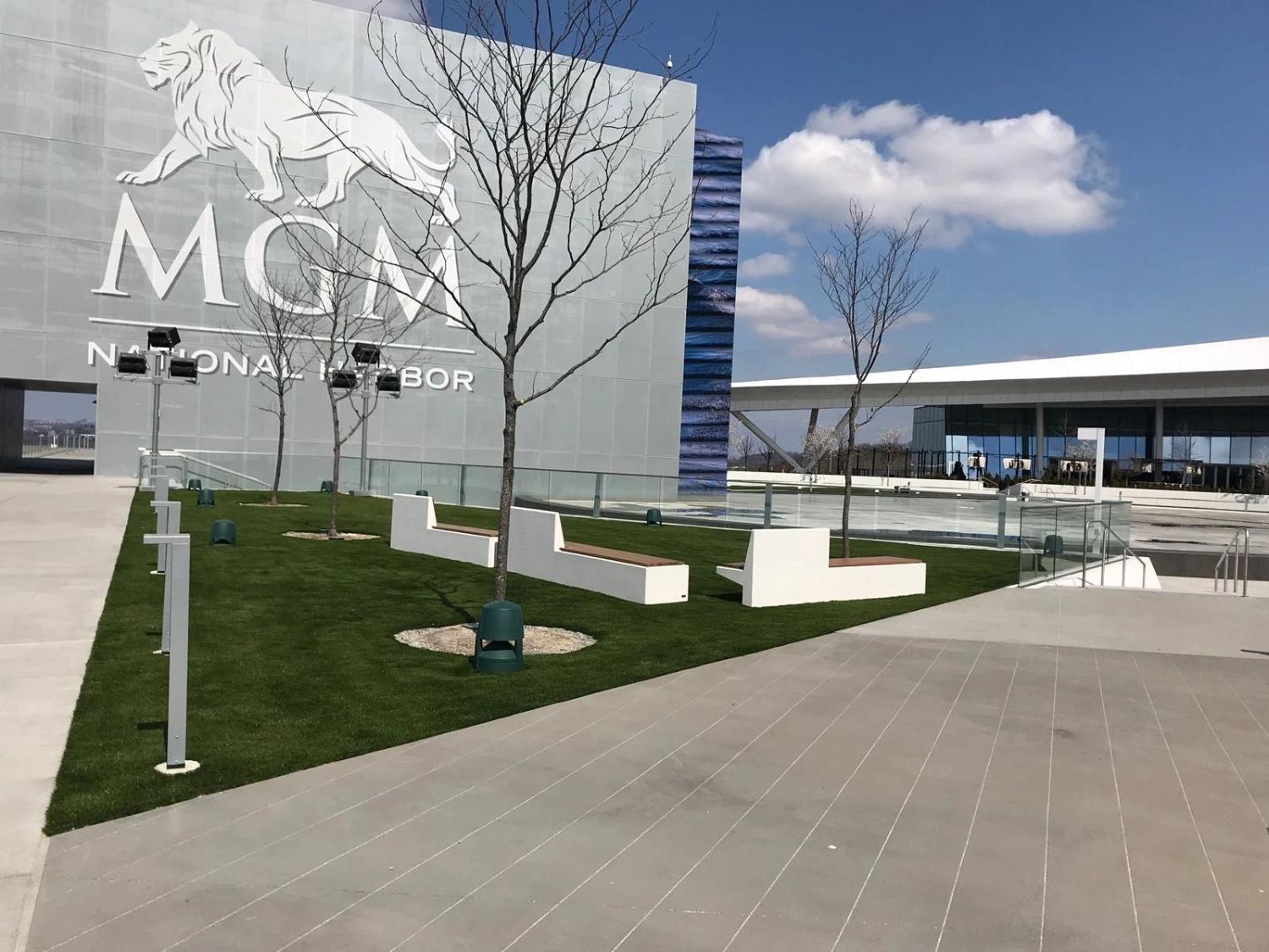 Modern commercial property with artificial grass landscaping, sleek architectural design, outdoor seating, and premium urban exterior space.