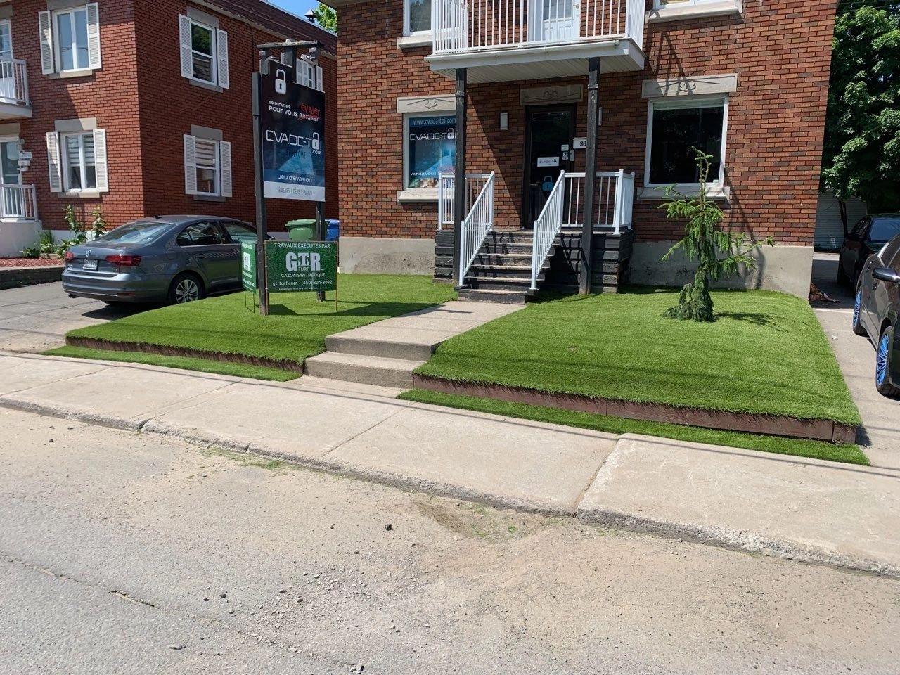 Commercial property front yard with professionally installed artificial grass lawn, clean landscaping, and low-maintenance urban exterior design.