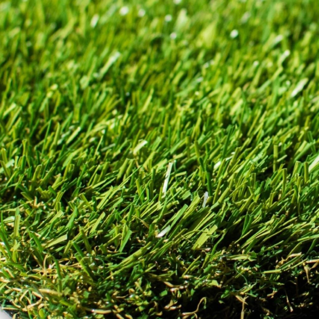 Detailed close-up of artificial turf with dense green blades, showcasing realistic texture and durability of synthetic grass.