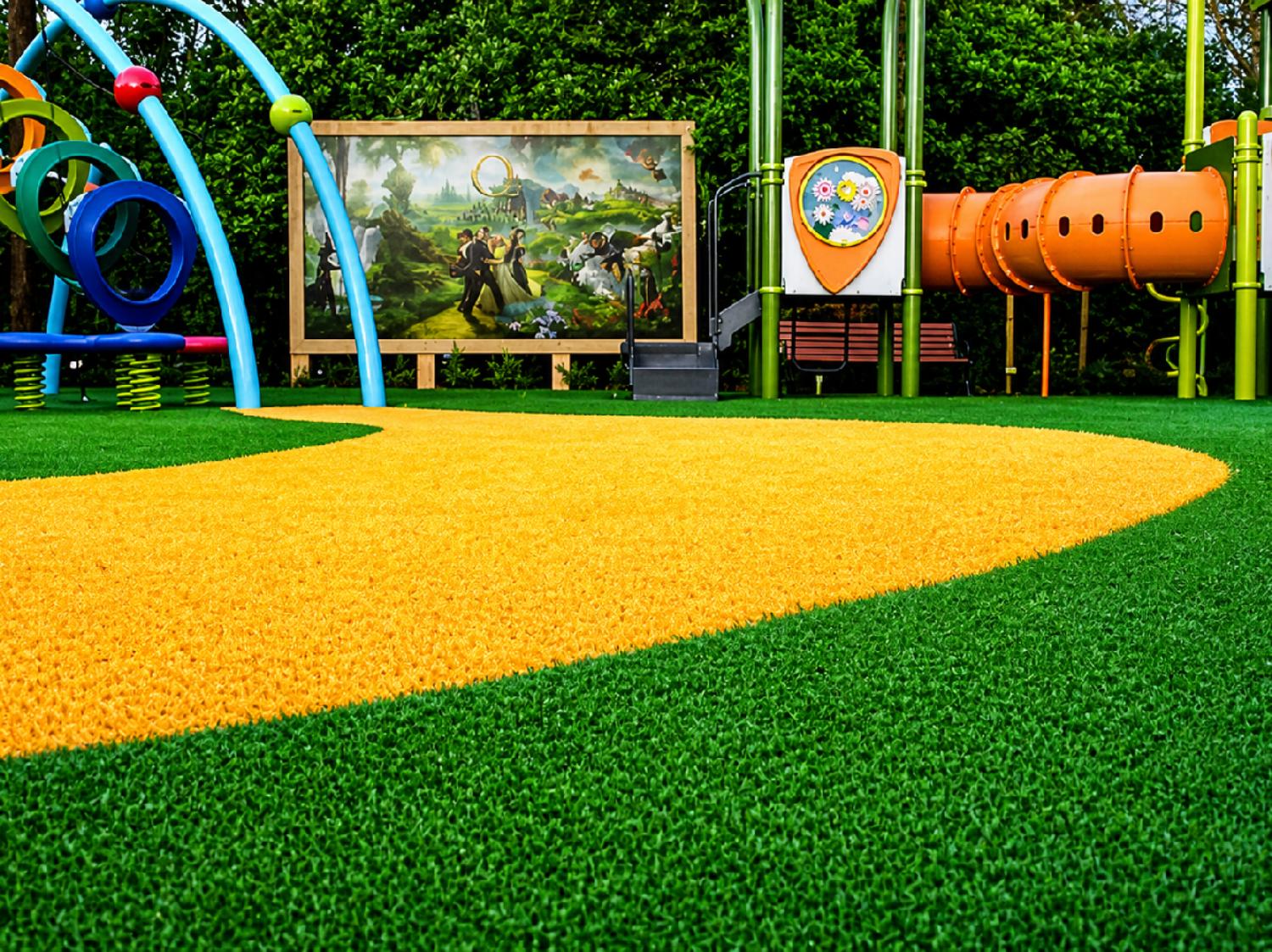 Colorful children’s playground with safety artificial turf surface, play equipment, and durable recreational landscaping for active outdoor play.